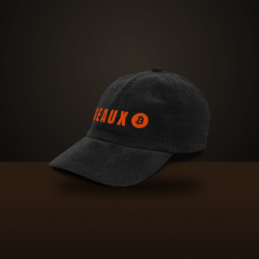 GEAUX ₿ corduroy cap on a walnut surface